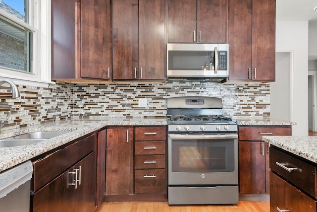 2910 N 76th Ct, Elmwood Park, IL 60707 - kitchen with stainless steel appliances, a sink, light stone countertops, light wood-type flooring, and tasteful backsplash