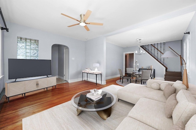 2910 N 76th Ct, Elmwood Park, IL 60707 - living room with arched walkways, stairway, wood finished floors, a ceiling fan, and baseboards