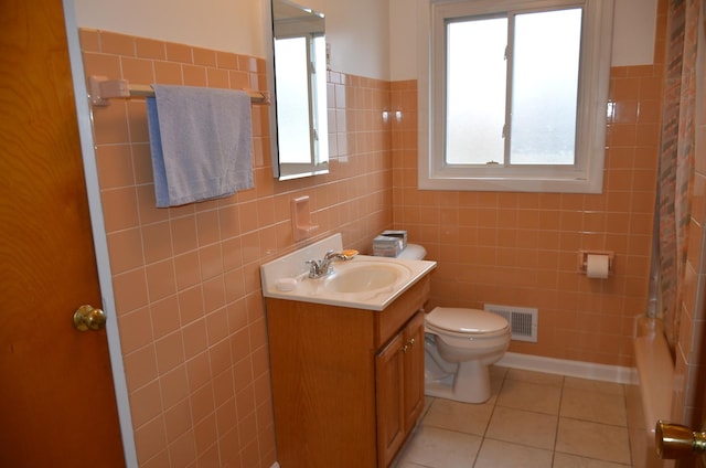 bathroom with tile patterned flooring, vanity, toilet, tile walls, and visible vents