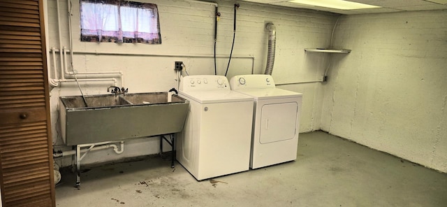 laundry area with laundry area, a sink, and washing machine and clothes dryer