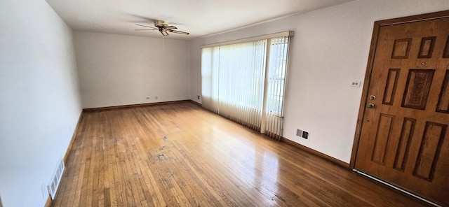 unfurnished room featuring baseboards, a ceiling fan, hardwood / wood-style flooring, and visible vents