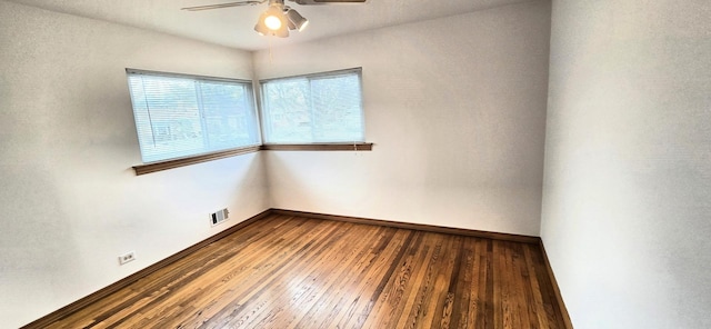 unfurnished room featuring baseboards, ceiling fan, visible vents, and hardwood / wood-style floors