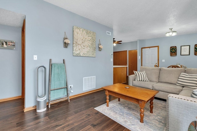living area featuring visible vents, dark wood-style flooring, baseboards, a textured ceiling, and a ceiling fan