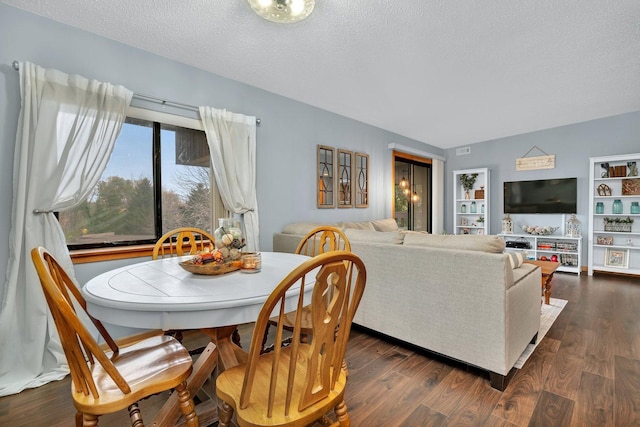 dining area with dark wood finished floors, a textured ceiling, and visible vents