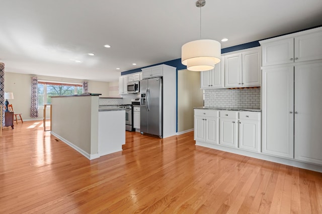 kitchen with light wood-style floors, white cabinetry, backsplash, and stainless steel appliances