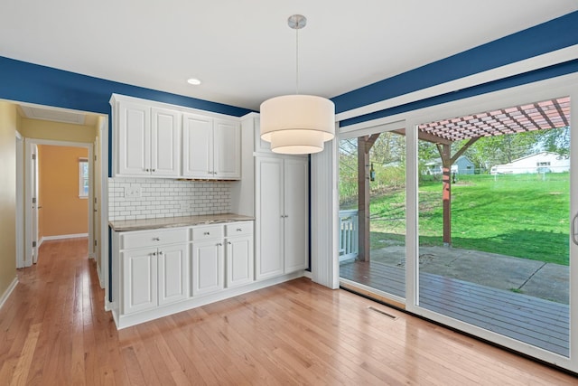 unfurnished dining area featuring light wood-style floors, recessed lighting, baseboards, and visible vents
