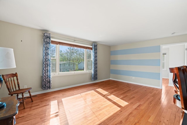 unfurnished room featuring baseboards and light wood-style floors
