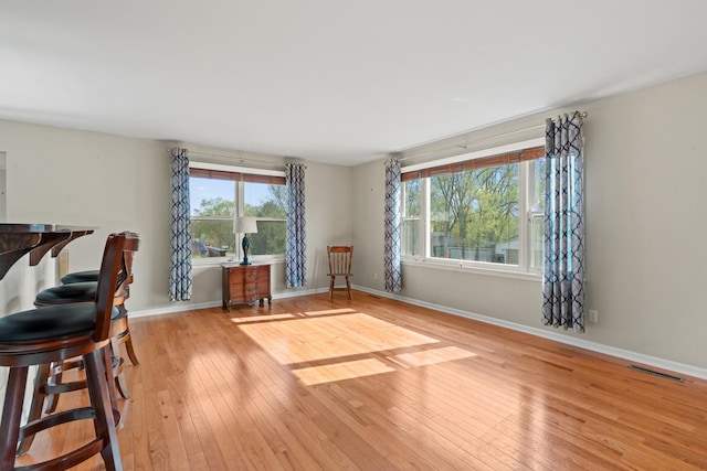 interior space with wood-type flooring, baseboards, and visible vents
