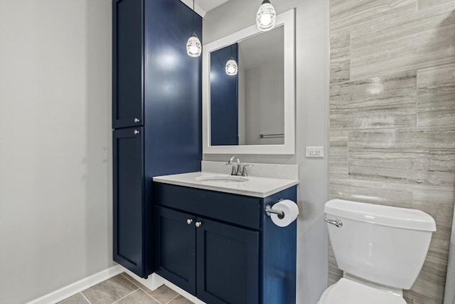 bathroom with vanity, tile patterned flooring, baseboards, and toilet