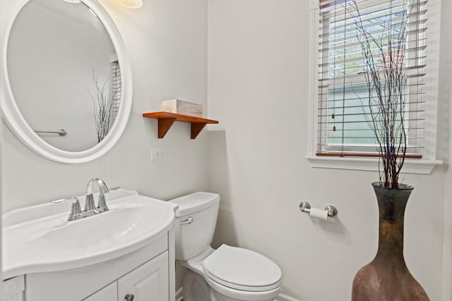 bathroom with vanity, baseboards, and toilet