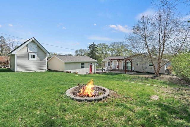 view of yard with an outbuilding, a fire pit, and a pergola