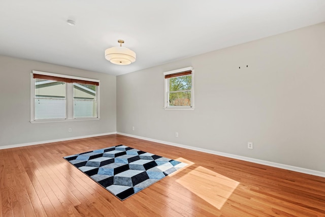 unfurnished room featuring baseboards and hardwood / wood-style floors