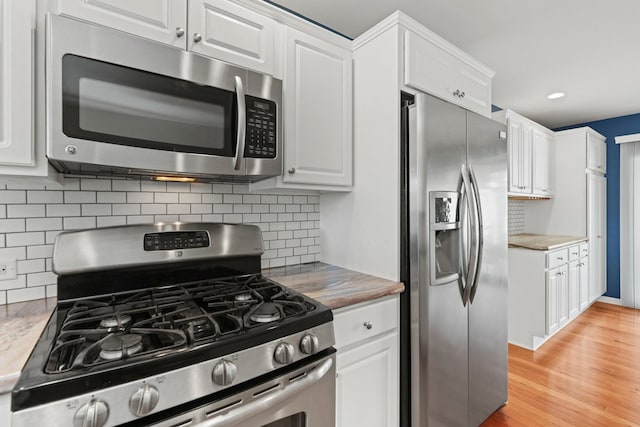 kitchen featuring light countertops, white cabinetry, appliances with stainless steel finishes, and decorative backsplash