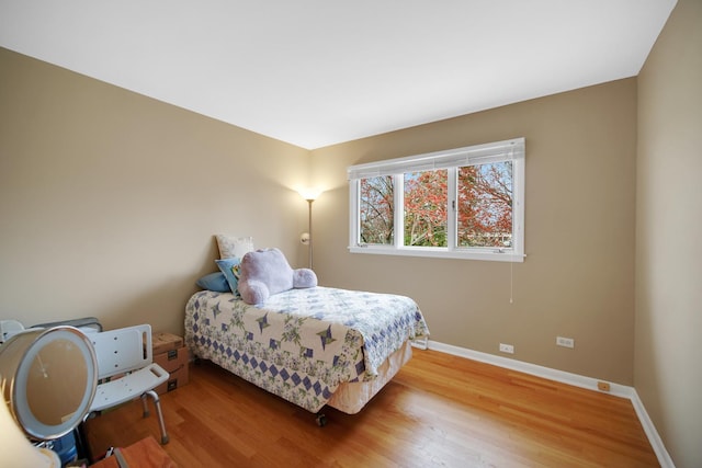 bedroom with baseboards and wood finished floors