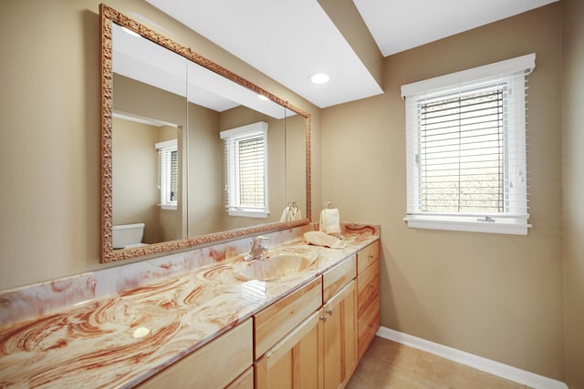 half bath with a healthy amount of sunlight, baseboards, and tile patterned flooring