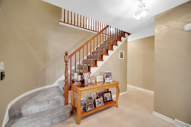 staircase featuring baseboards, tile patterned flooring, and visible vents