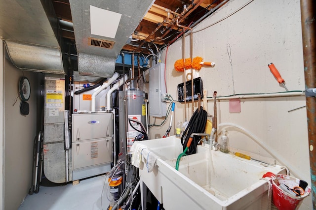 utilities featuring heating unit, gas water heater, a sink, and visible vents