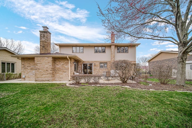 rear view of property featuring fence, a chimney, a yard, and a patio area