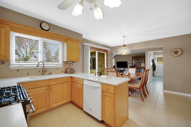 kitchen with a sink, white dishwasher, plenty of natural light, and a peninsula