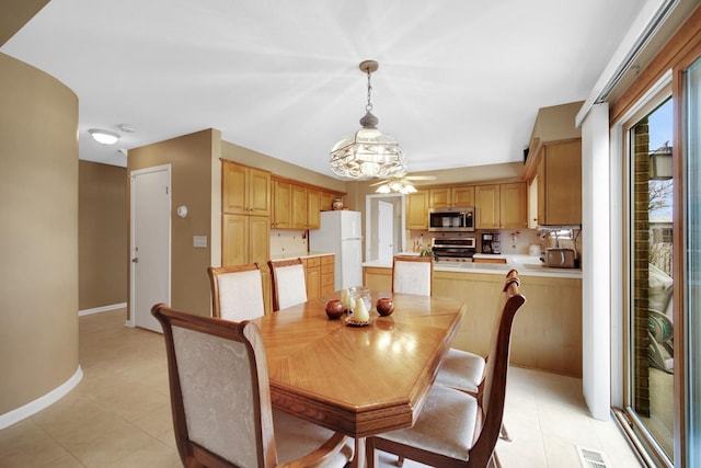 dining room featuring baseboards, a ceiling fan, and visible vents