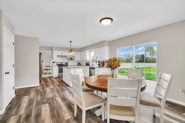 dining space with baseboards and dark wood-style flooring