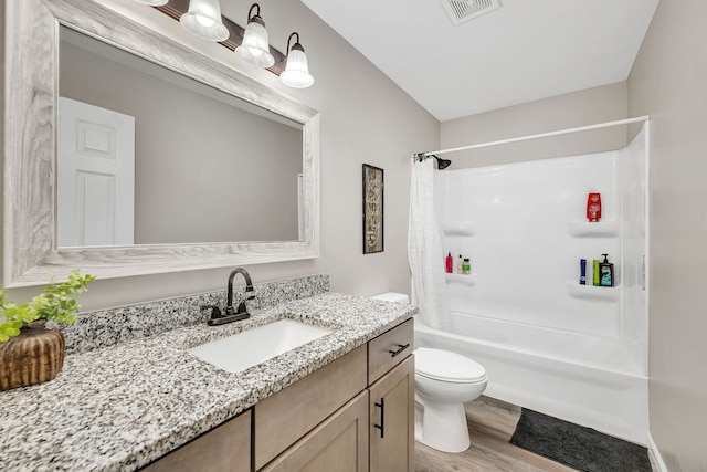 bathroom with visible vents, shower / bath combo with shower curtain, vanity, wood finished floors, and toilet
