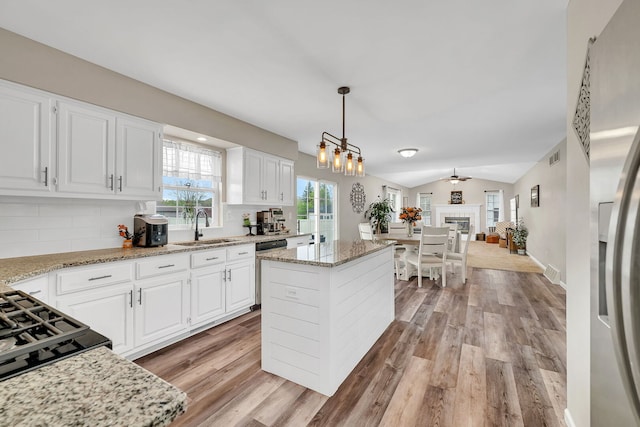 kitchen featuring light wood-type flooring, a sink, backsplash, and stainless steel appliances