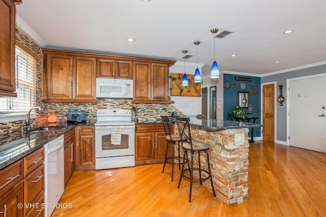 9459 Kelvin Ln Unit 2665, Schiller Park, IL 60176 - kitchen with brown cabinetry, a breakfast bar area, tasteful backsplash, a sink, and white appliances