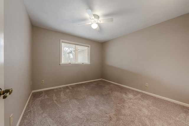 carpeted empty room featuring baseboards and a ceiling fan