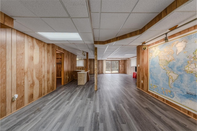 below grade area with wood walls, a paneled ceiling, and wood finished floors