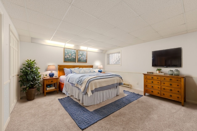 carpeted bedroom featuring a drop ceiling and baseboard heating