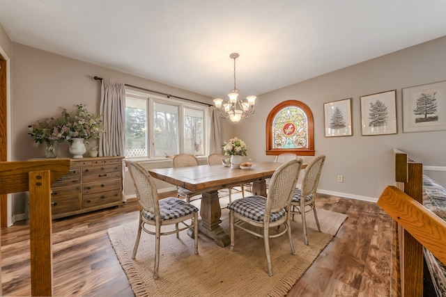 dining room with baseboards, wood finished floors, a notable chandelier, and a healthy amount of sunlight