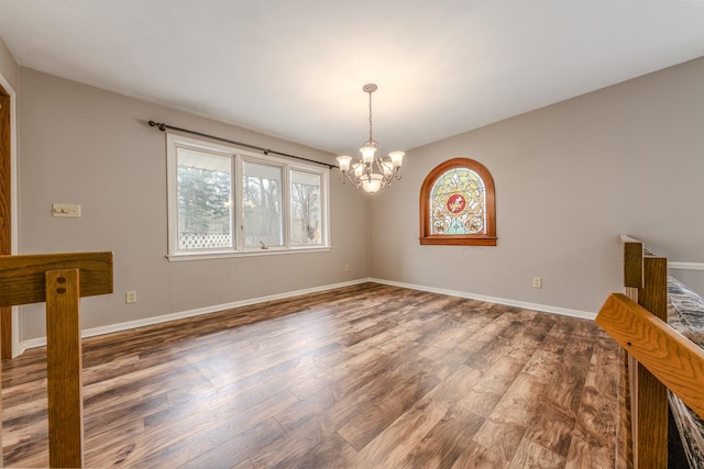 interior space with baseboards, wood finished floors, and a notable chandelier