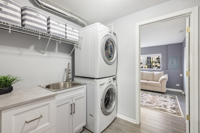 168 Willow Blvd, Willow Springs, IL 60480 - clothes washing area with stacked washer and clothes dryer, cabinet space, baseboards, and light wood finished floors