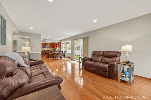 living area with light wood finished floors, baseboards, and recessed lighting