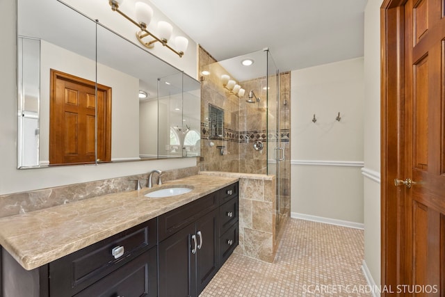 full bath with vanity, baseboards, a shower stall, and tile patterned flooring