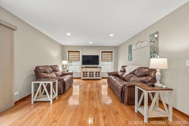 living room featuring light wood-type flooring, baseboards, and recessed lighting