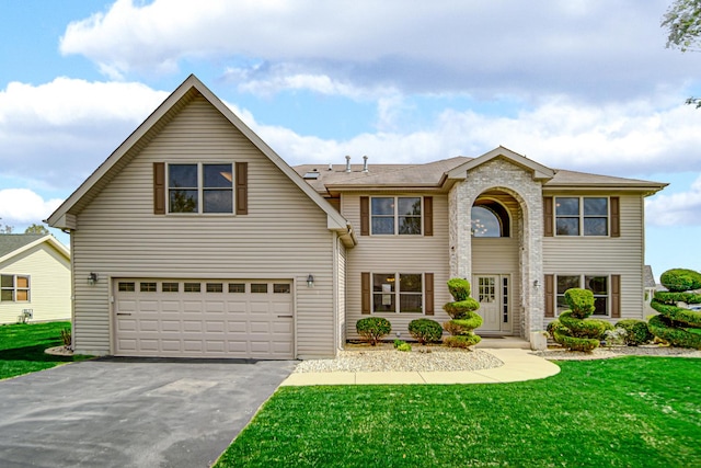 view of front of house featuring a garage, driveway, and a front yard
