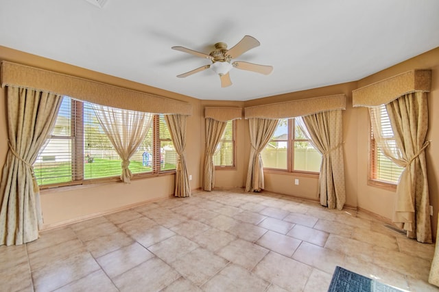 empty room with baseboards and ceiling fan