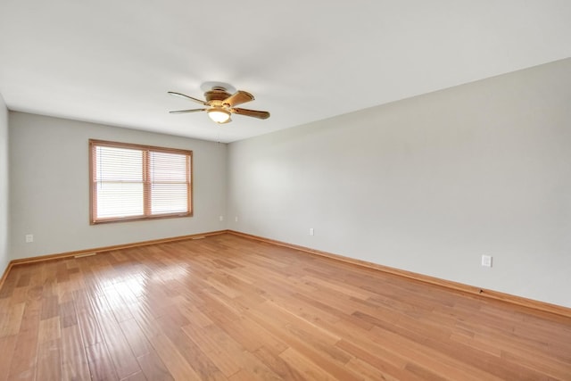 empty room with ceiling fan, baseboards, and light wood-type flooring