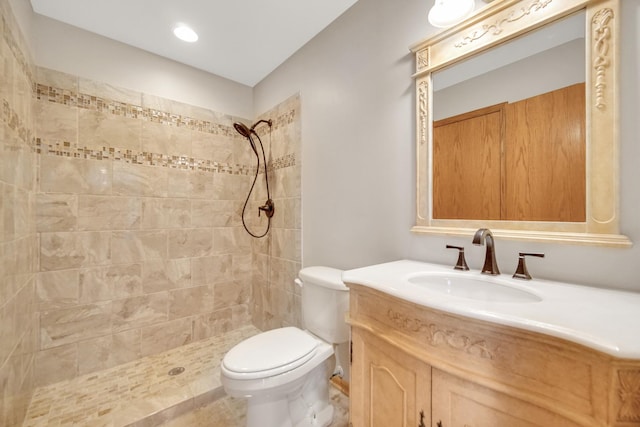 full bath with toilet, a tile shower, and vanity