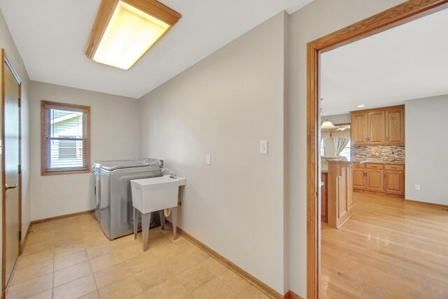 laundry room with washer and dryer, laundry area, a sink, and baseboards