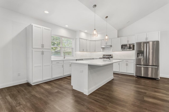 kitchen with appliances with stainless steel finishes, light countertops, white cabinets, tasteful backsplash, and vaulted ceiling