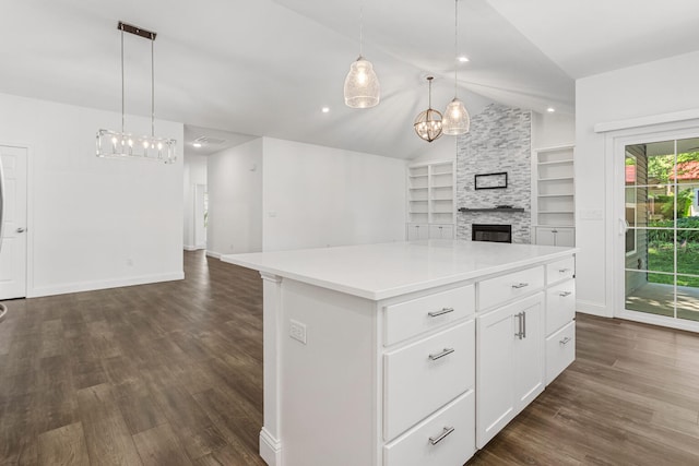 kitchen with open floor plan, a chandelier, a large fireplace, dark wood finished floors, and lofted ceiling