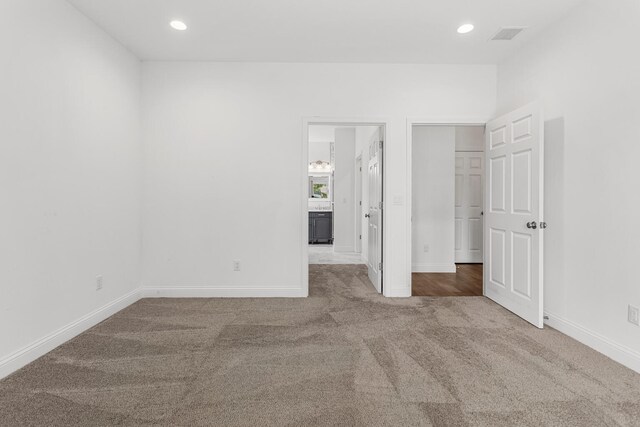 unfurnished bedroom with carpet floors, baseboards, recessed lighting, and ensuite bathroom