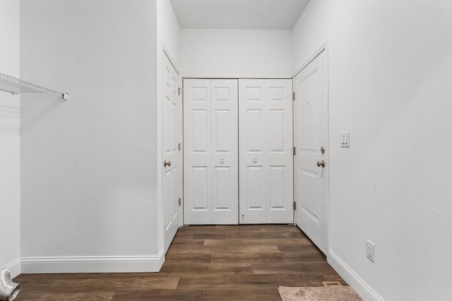 corridor featuring dark wood finished floors and baseboards