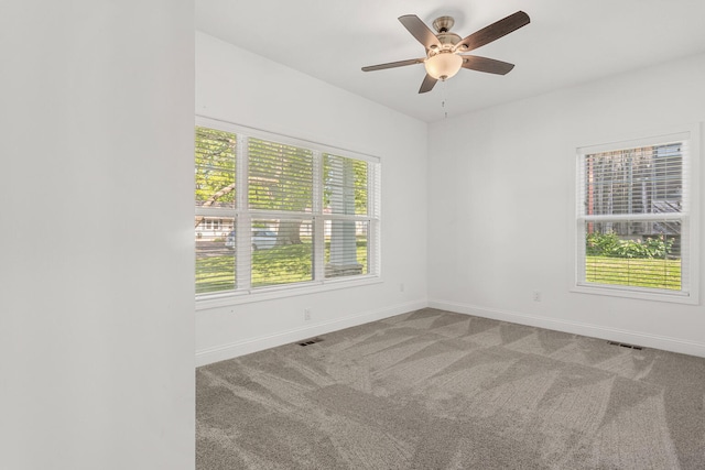 empty room featuring carpet floors, baseboards, and a ceiling fan