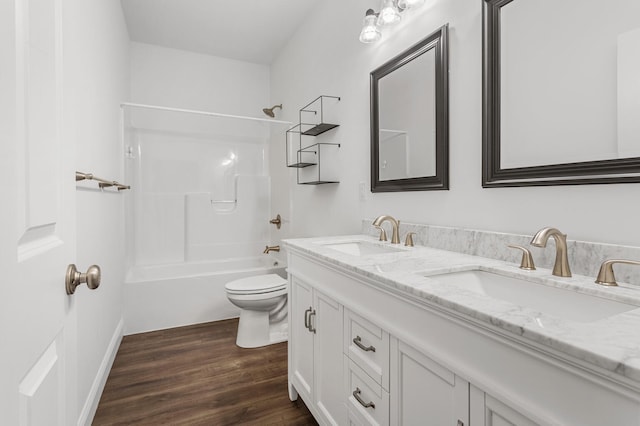 full bathroom with wood finished floors, double vanity, bathtub / shower combination, toilet, and baseboards