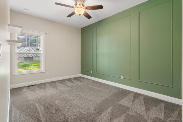 carpeted spare room featuring ceiling fan, baseboards, and a smoke detector
