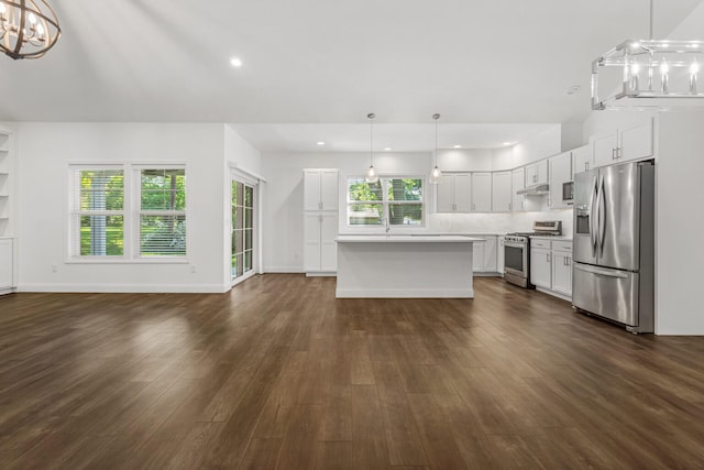 unfurnished living room featuring dark wood-style floors, a chandelier, recessed lighting, and baseboards